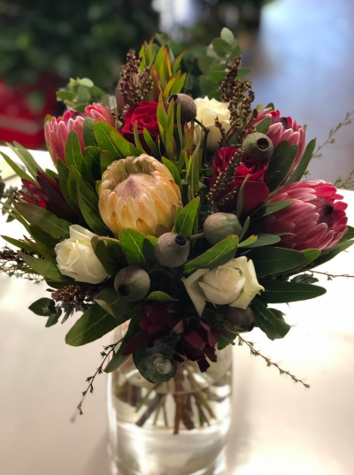 Winter Wonder - A beautiful range of winter's native flowers and a couple of roses to add a pop of richness to the texture of the proteas. Designed in a vase so that this arrangement is ready to be displayed as the recipient receives such a gift of beauty.